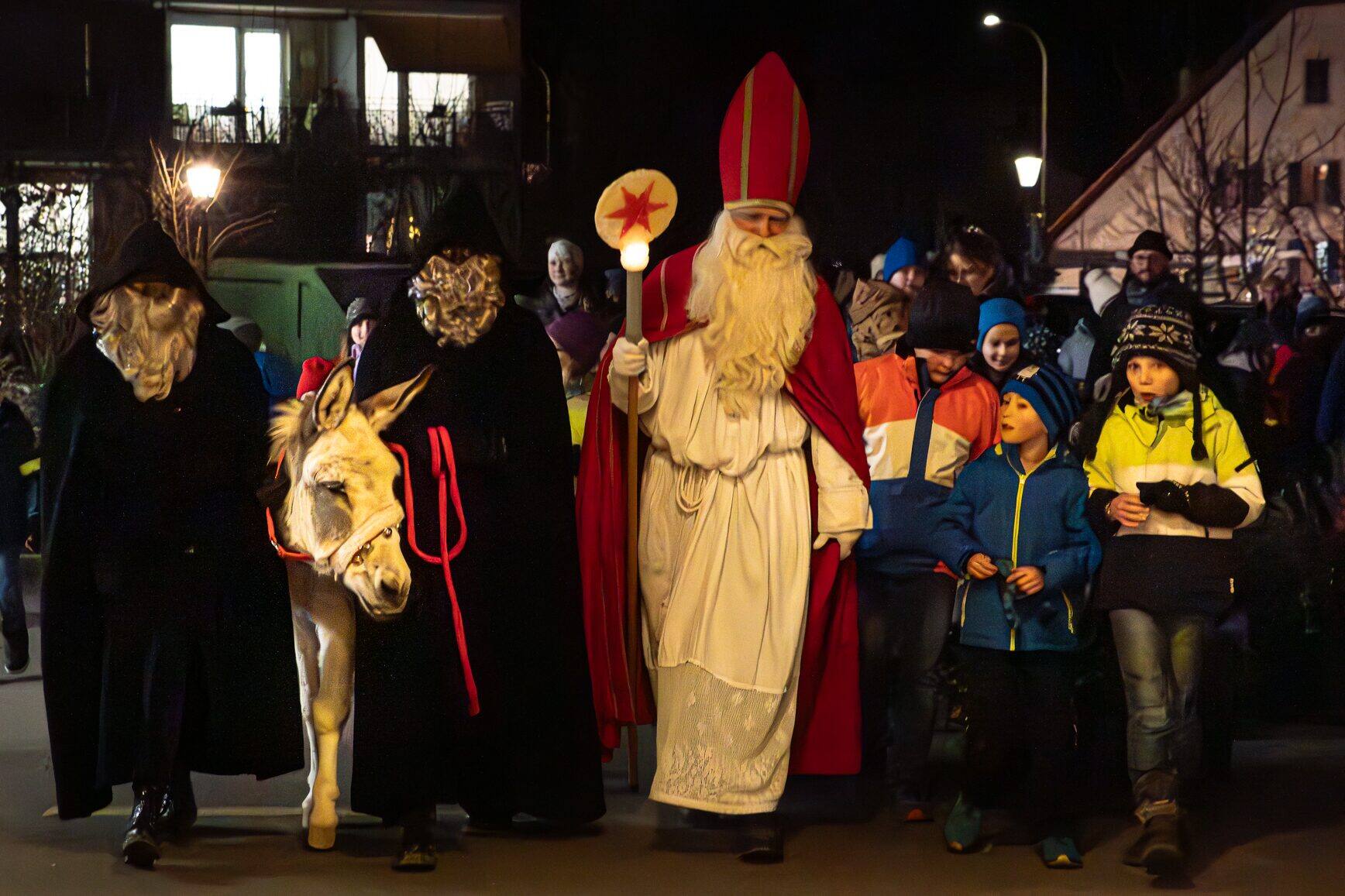 Samichlaus, Schmutzli und Esel ziehen mit Kindern durchs Dorf